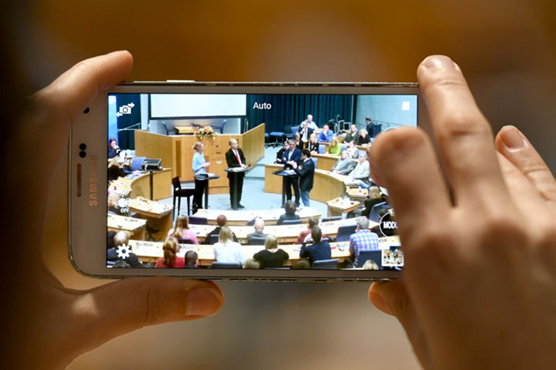 Blick durch die Kamera eines Smartphones auf den Plenarsaal