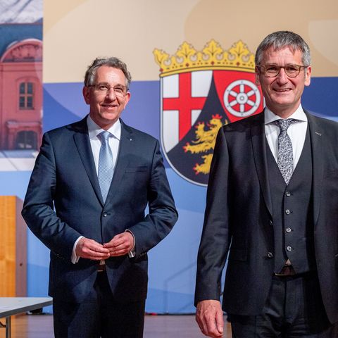 Die drei hochrangigen Politiker stehen vor dem Landeswappen des Landes Rheinland-Pfalz.