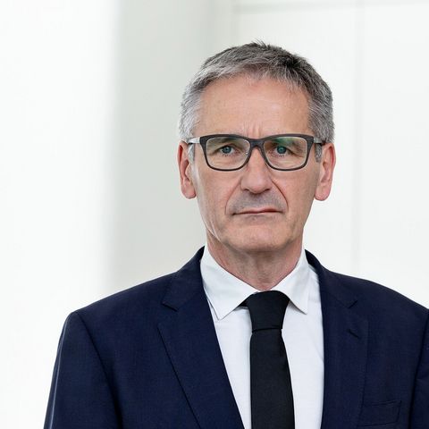 Landtagspräsident Hendrik Hering mit ernstem Gesichtsausdruck. Er steht vor einem Fenster. das Bild wirkt hell und licht.