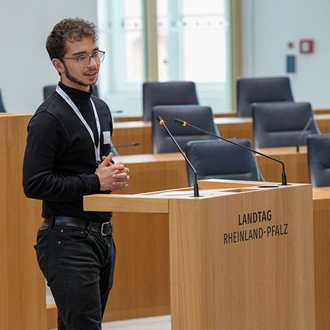 Ein Auszubildender spricht am Rednerpult im Plenarsaal