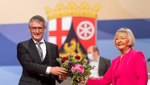 Sie übergeben einander einen Blumenstrauß