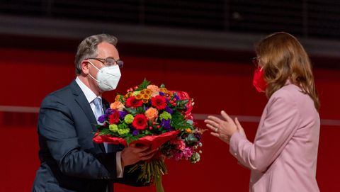 Er übergibt an eine Abgeordnete einen Blumenstrauß