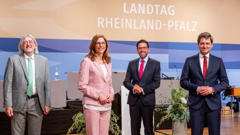 Die Fraktionsvorsitzenden stehen auf der Rednerflächen vor dem Logo des Landtags Rheinland-Pfalz.