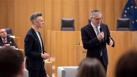 Landtagspräsident Hendrik Hering spricht in das Mikrofon. Marvin Neumann steht neben ihm.