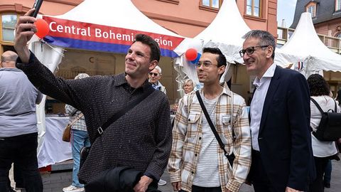 Zwei junge Männer positionieren sich zusammen mit dem Landtagspräsidenten, um ein Selfie aufzunehmen.
