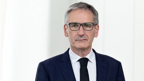Landtagspräsident Hendrik Hering mit ernstem Gesichtsausdruck. Er steht vor einem Fenster. das Bild wirkt hell und licht.