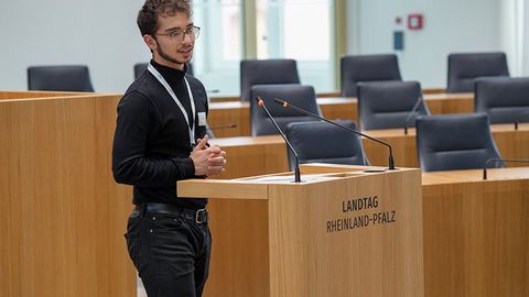 Ein Auszubildender spricht am Rednerpult im Plenarsaal