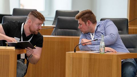 Zwei Teilnehmende tauschen sich flüsternd aus.