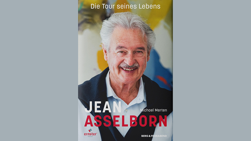 Zu sehen ist ein Mann. Er l&auml;chelt den Betrachter an. &Uuml;ber dem Kopf des Mannes steht mit wei&szlig;er Schrift: "Die Tour seines Lebens". Unterhalb steht in gr&ouml;&szlig;erer Schrift: "Jean Asselborn". Hierbei handelt es sich um ein Buch-Cover.