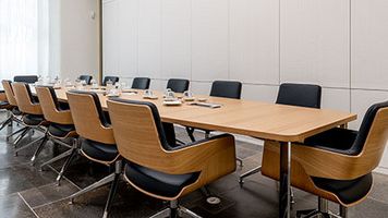 Zu sehen ist der Besprechungsraum mit Stühlen und Tischen aus erhöhter Perspektive