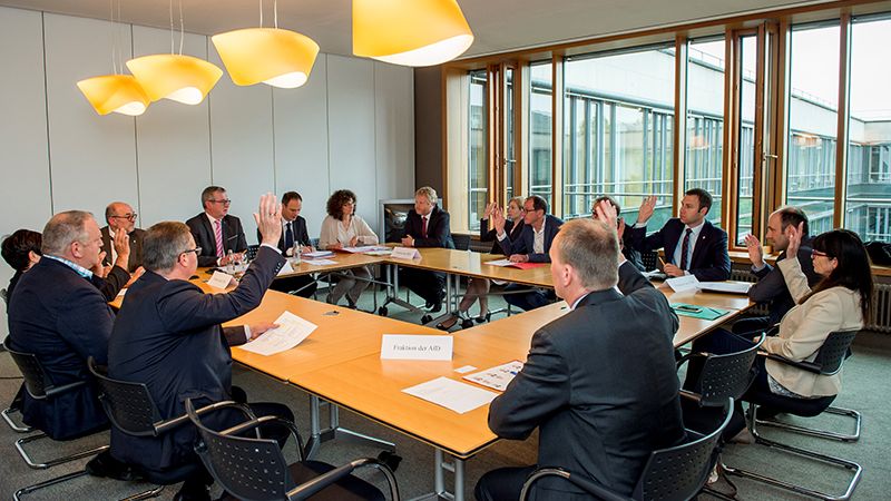 Die Abgeordneten arbeiten in einer kleinen Gruppen um den Tisch im Besprechungsraum