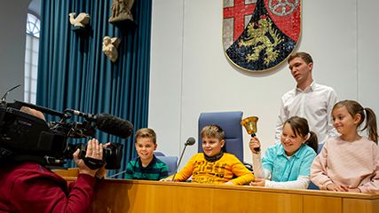 Ausschnitt aus dem Grundschulprogramm. Die Schüler:innen sitzen im Plenarsaal auf den Plätzen der Sitzungsleitung.