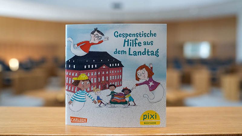 Das neue Pixi-Buch „Gespenstische Hilfe aus dem Landtag“. Hier zu sehen ist ein Bild vom Pixi-Buch augenommen im leeren Plenarsaal.