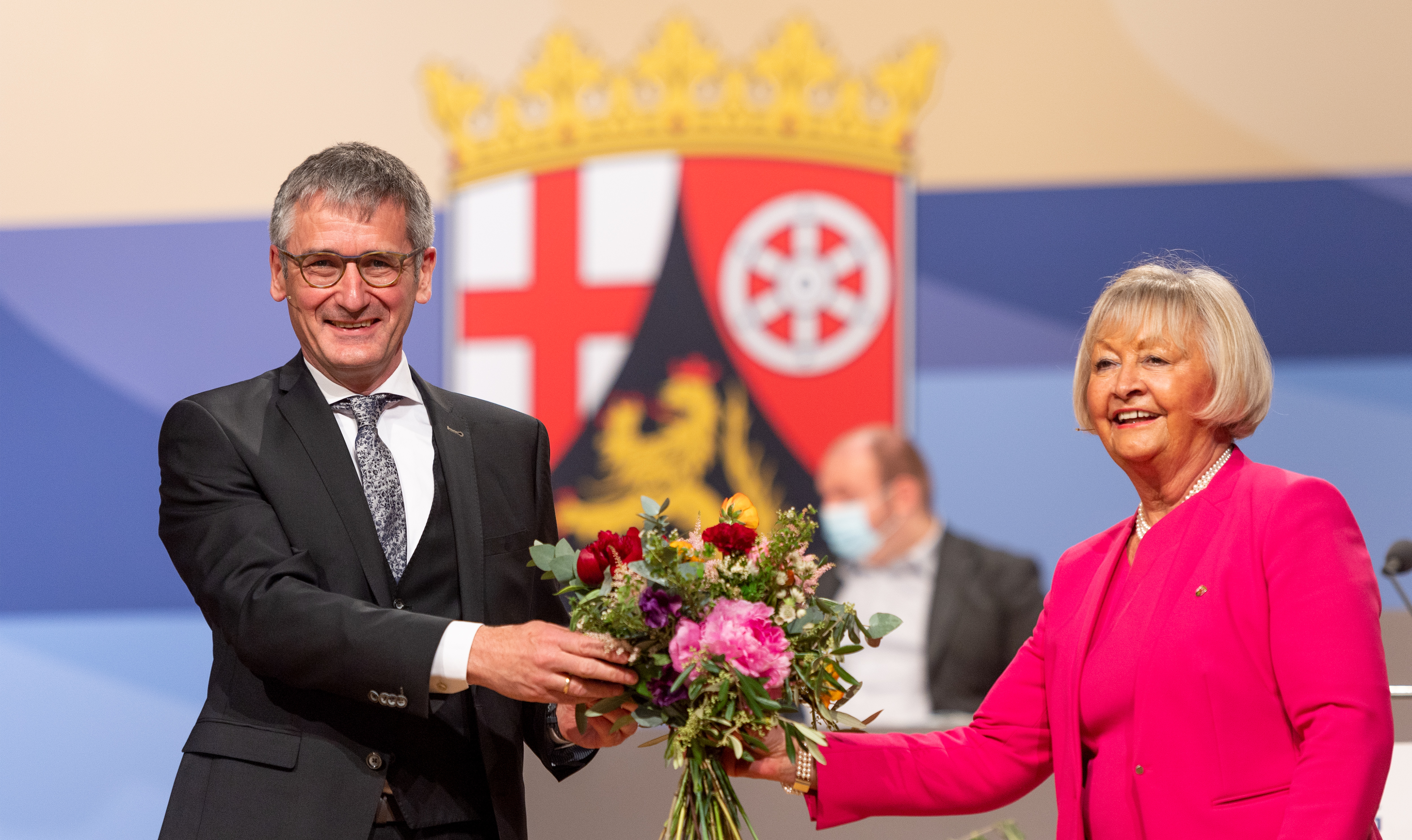 Sie übergeben einander einen Blumenstrauß