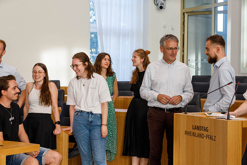 Ein Besuchergruppe unterhaölt sich mit Landtagspräsident Hendrik Hering im Plenarsaal.