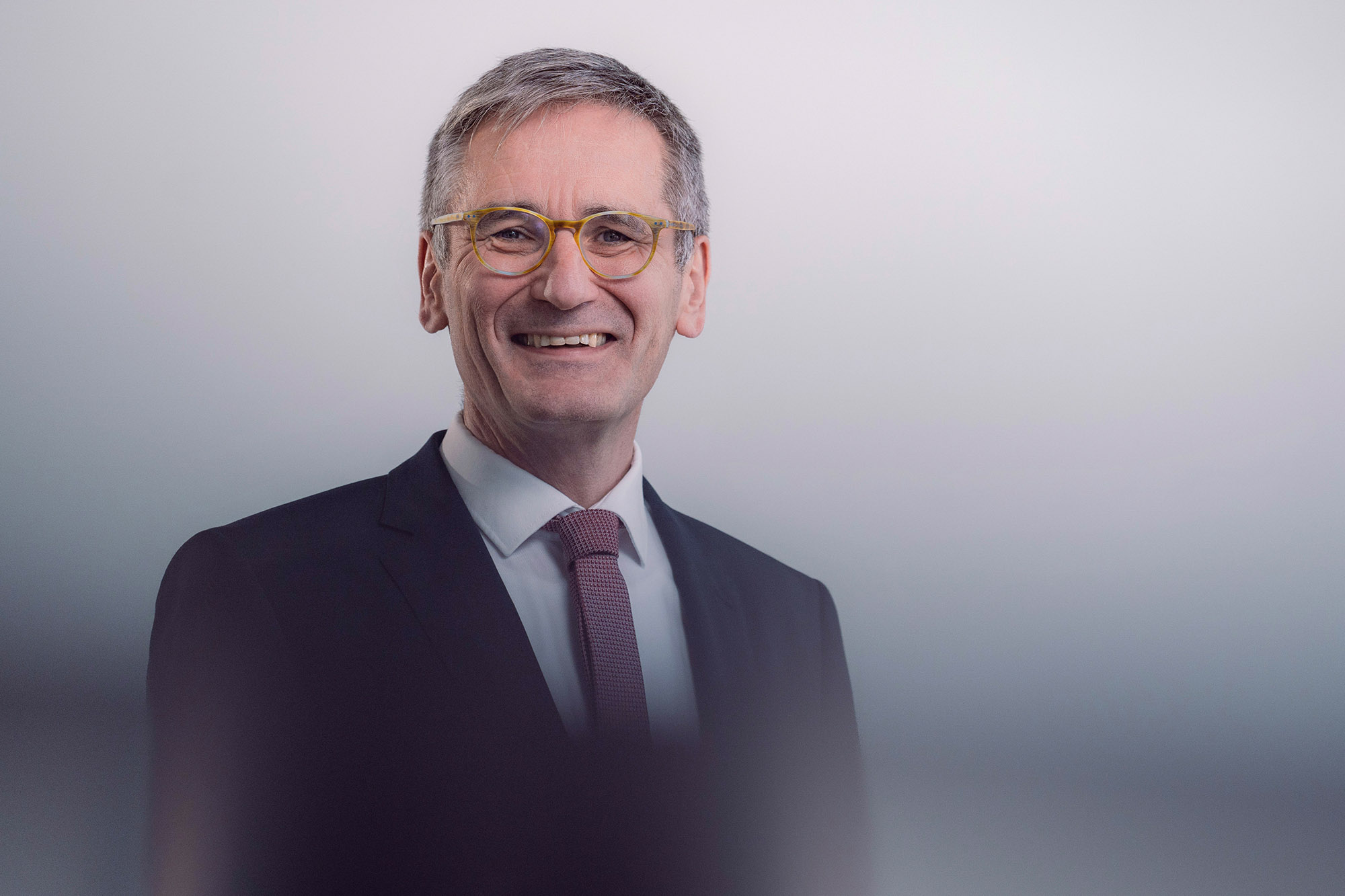 Portrait des Landtagspräsidenten Rheinland-Pfalz,  Hendrik Hering; der Präsident trägt ein dunkelgraues Jacket und eine rot-weiß gemusterte Krawatte; das Bild ist mit Unschärfe-Effekten bearbeitet