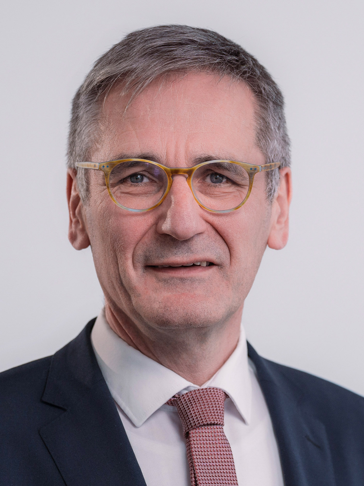 Portrait des Landtagspräsidenten Rheinland-Pfalz,  Hendrik Hering; das Bild ist hochkant; der Präsident trägt ein dunkelgraues Jacket und eine rot-weiß gemusterte Krawatte