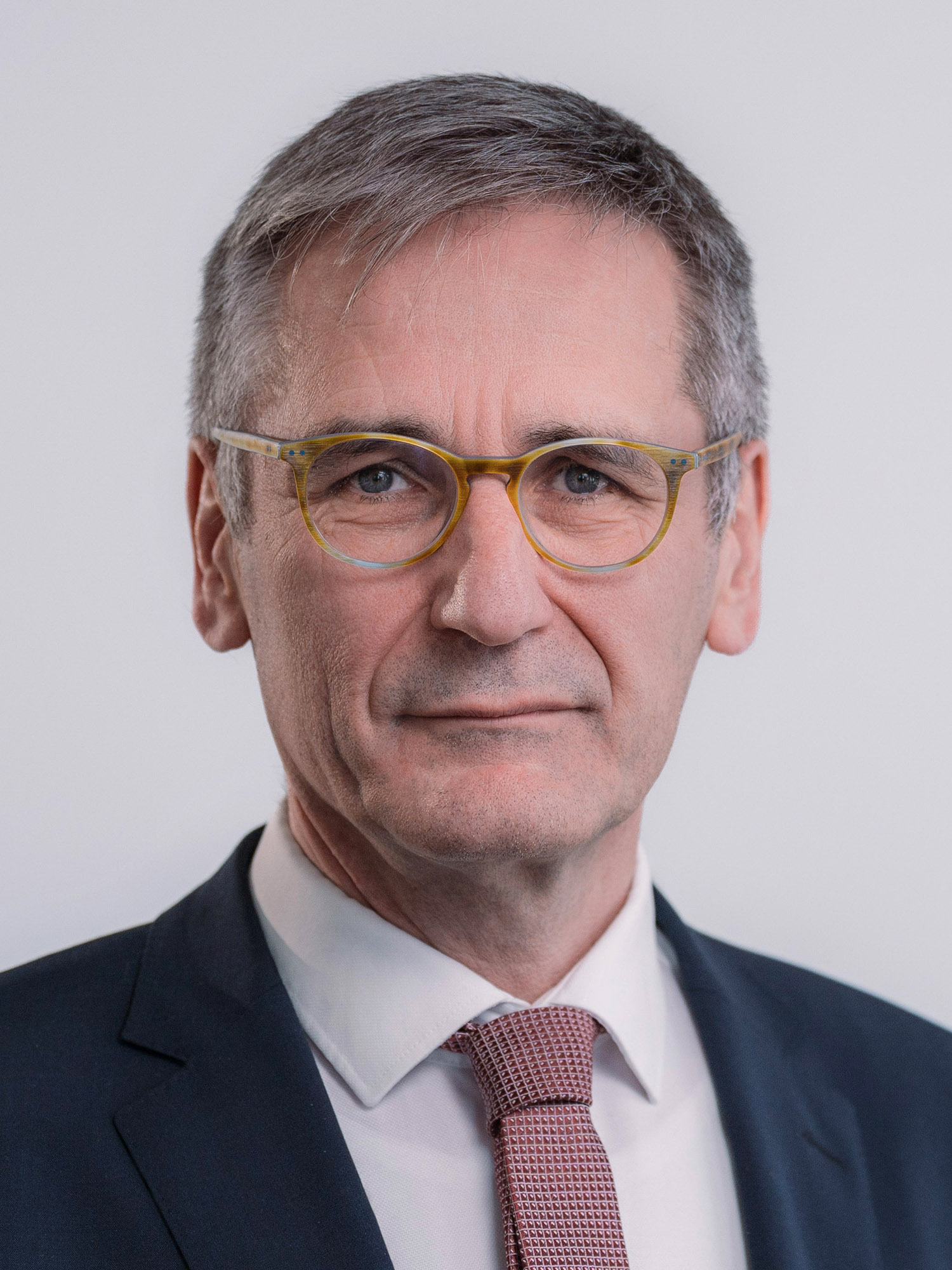 Portrait des Landtagspräsidenten Rheinland-Pfalz,  Hendrik Hering; das Bild ist hochkant; der Präsident trägt ein dunkelgraues Jacket und eine rot-weiß gemusterte Krawatte