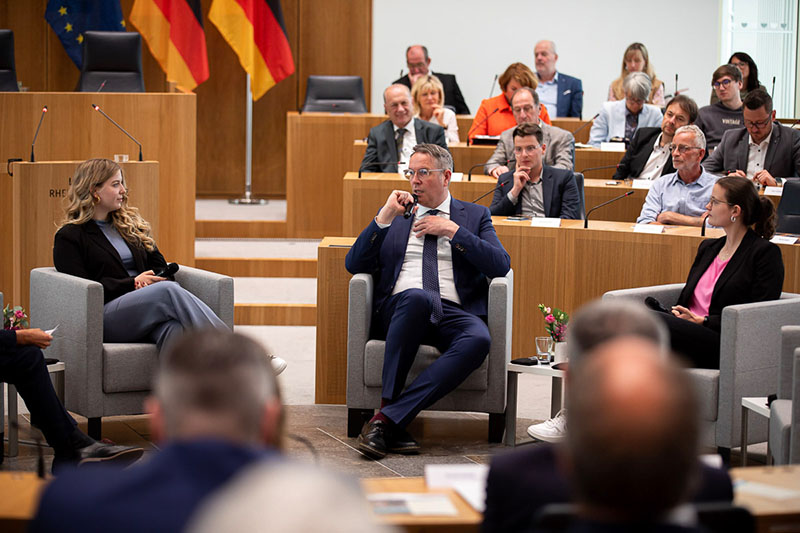 Ministerpräsident Alexander Schweitzer spricht in das Mikrofon. Zu beiden Seiten sitzen Gesprächspartnerinnen der Talk-Runde.
