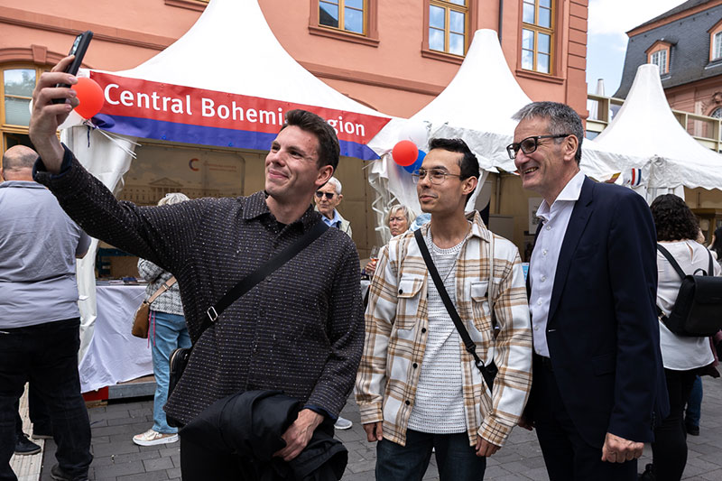 Zwei junge Männer positionieren sich zusammen mit dem Landtagspräsidenten, um ein Selfie aufzunehmen.