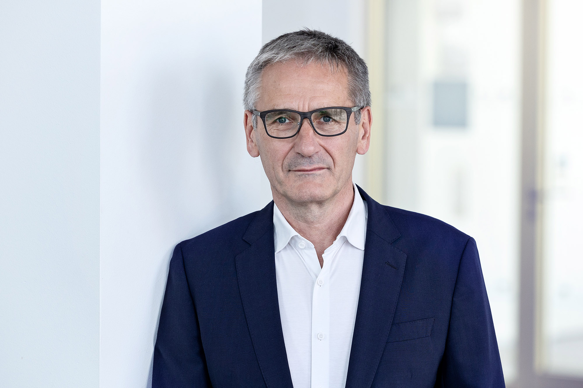 Landtagspräsident Hendrik Hering mit ernstem Gesichtsausdruck. Er steht vor einem Fenster. Das Bild wirkt hell und licht.