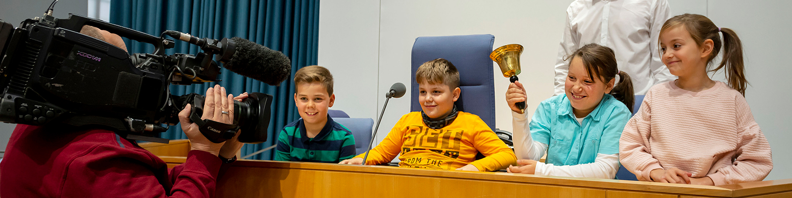 Ausschnitt aus dem Grundschulprogramm. Die Schüler:innen sitzen im Plenarsaal auf den Plätzen der Sitzungsleitung.
