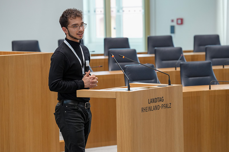 Ein Auszubildender spricht am Rednerpult im Plenarsaal